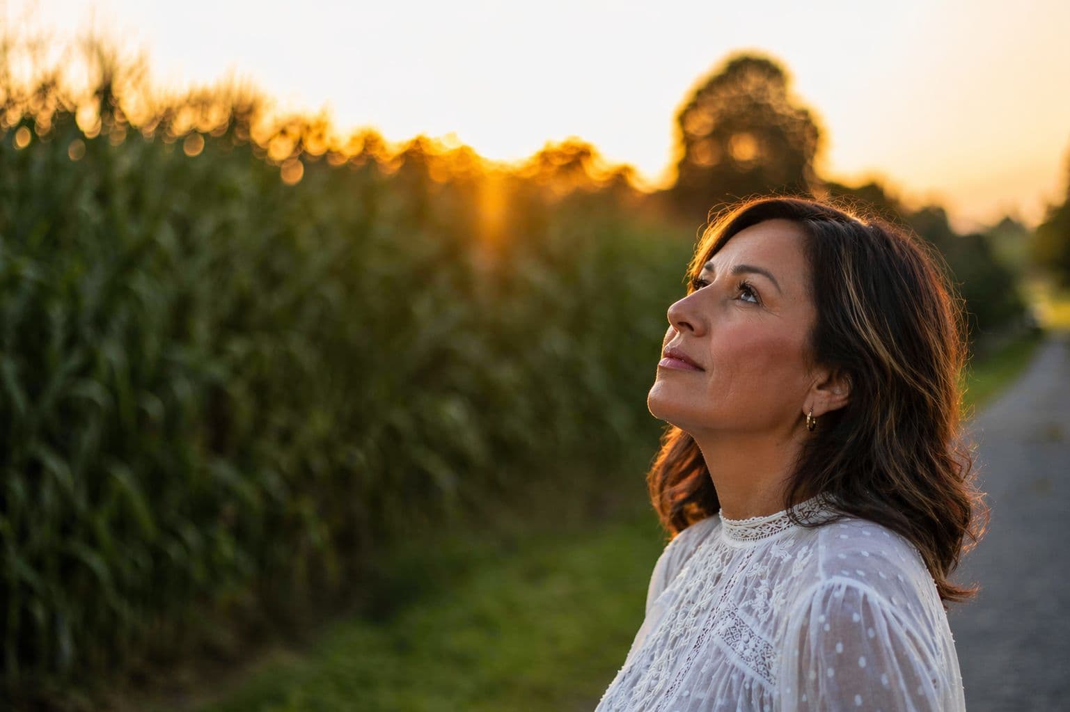 Woman looking upward outdoors at sunset