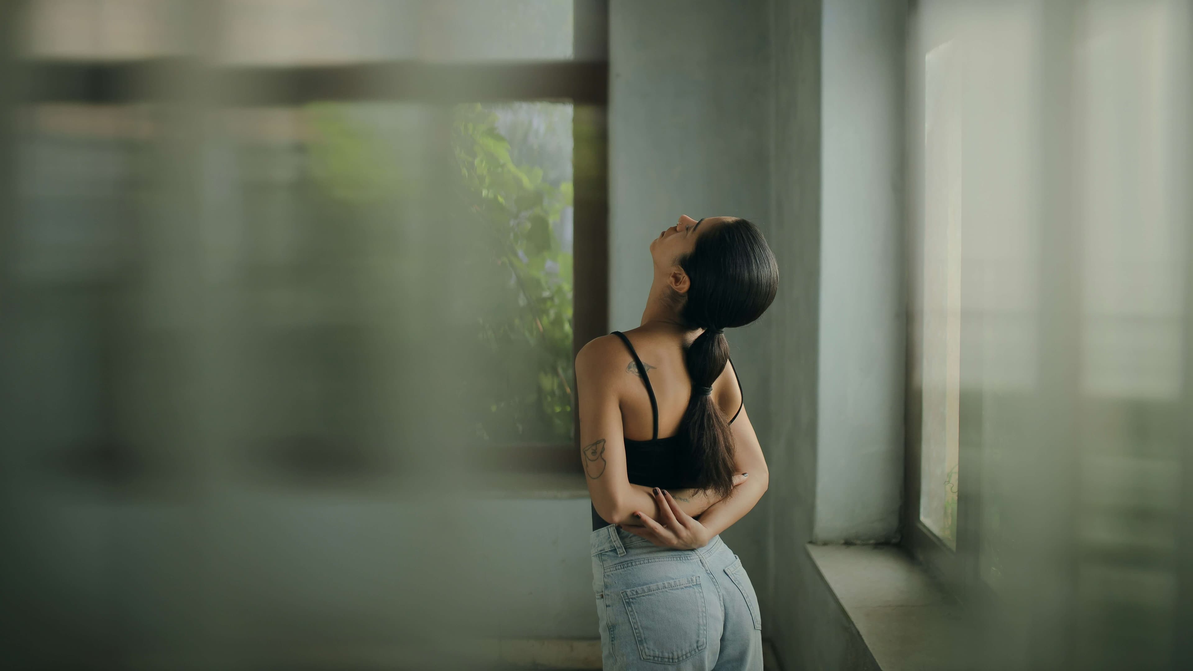 Person stretching carefully near a window