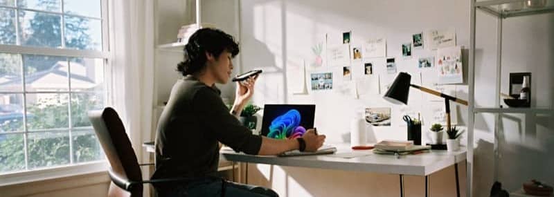 Person working at desk with laptop and phone.